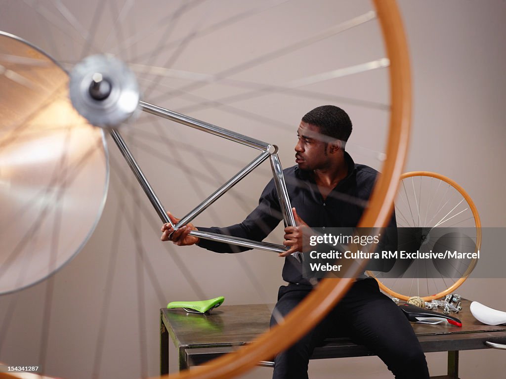 Businessman examining bicycle part