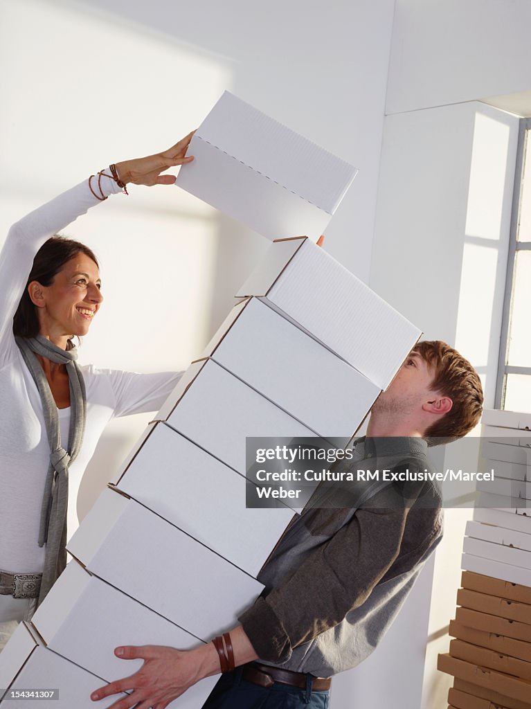 Business people carrying stack of boxes