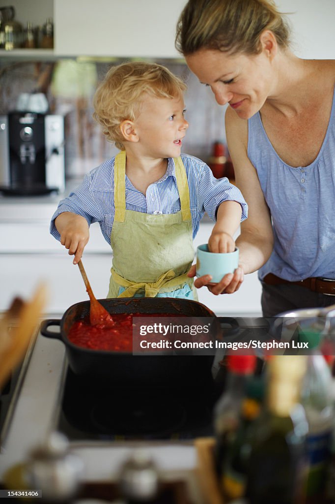 Mother and son cooking in kitchen