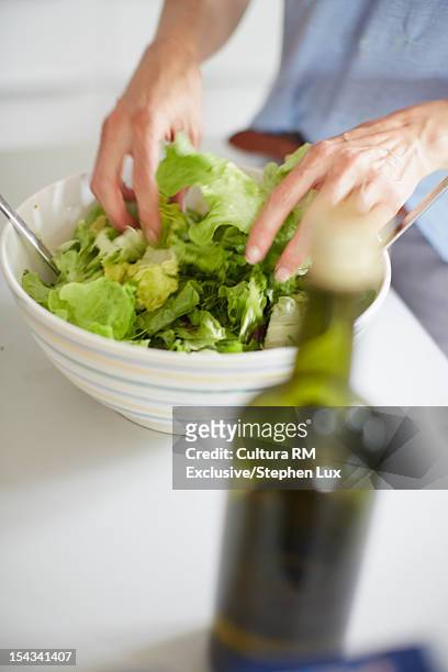 close up of woman tossing salad - würzen stock-fotos und bilder