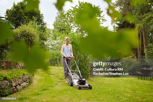 woman mowing backyard lawn - mowing lawn stock-fotos und bilder