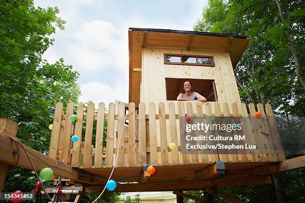 woman standing in treehouse window - tree house stock pictures, royalty-free photos & images