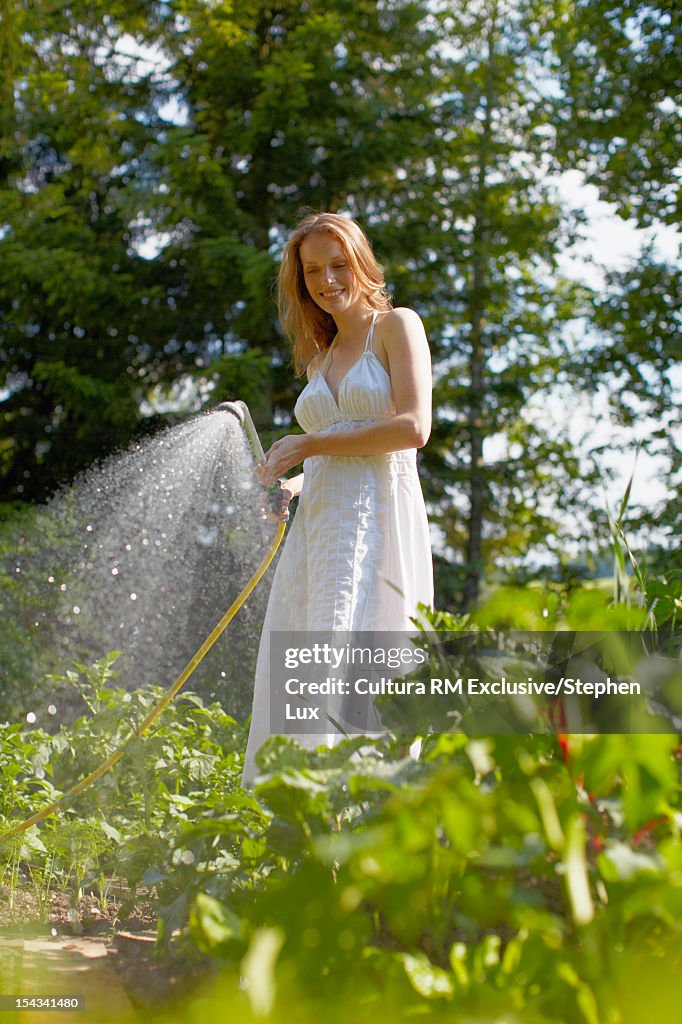 Woman watering vegetable garden