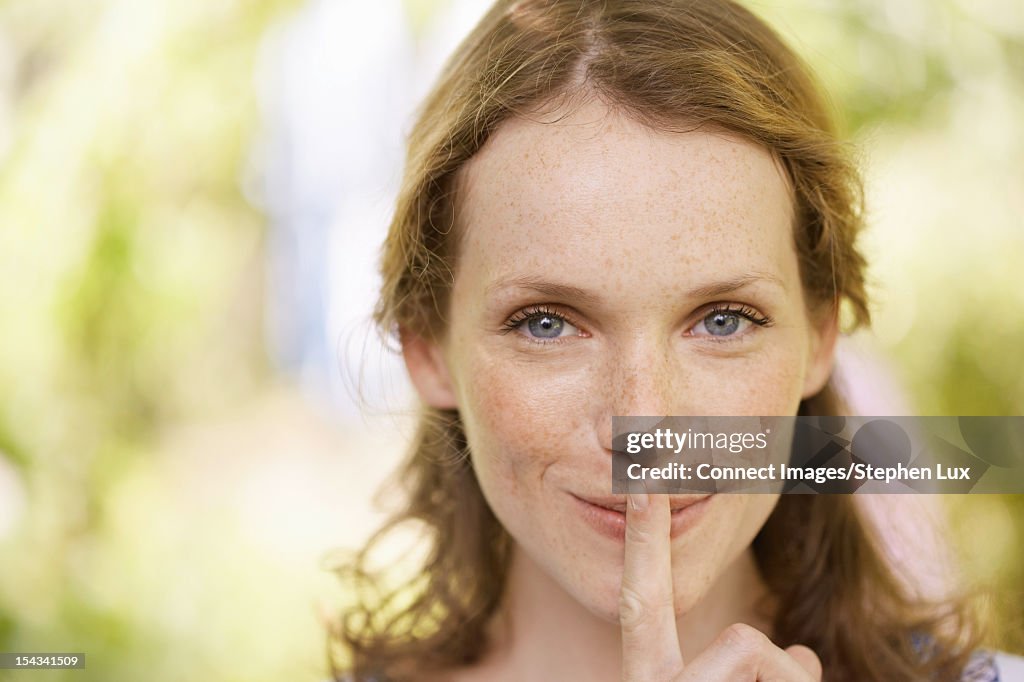 Woman holding finger over her lips