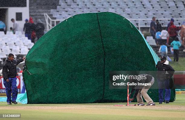 Raincovers are brought onto the pitch by groundstaff during the Karbonn Smart CLT20 match between Mumbai Indians and Yorkshire at Sahara Park...