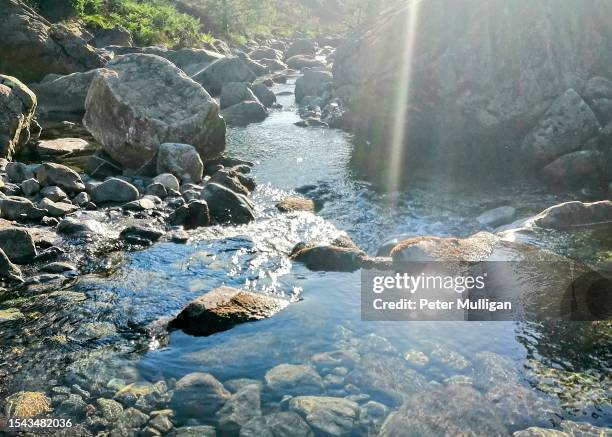 sunlight flash in a clear pool: river liza in ennerdale, english lake district - bachlauf stock-fotos und bilder