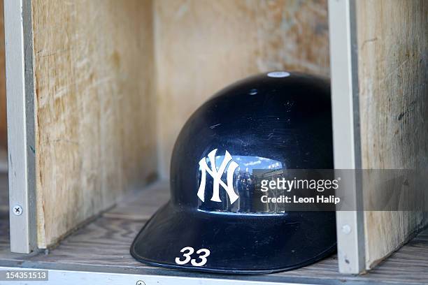 The batting helmet belonging to Nick Swisher of the New York Yankees sits in the shelf in the dugout against the Detroit Tigers during game four of...