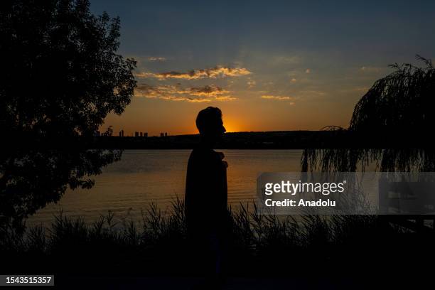 Silhouette of a man during sunset at Lake Mogan, in Ankara, Turkiye on July 19, 2023.