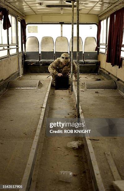 Lance Corporal John Evans, 24 from Flint in North Wales, searches a bus during stop and search operations carried out by B Squadron, The Queen's...