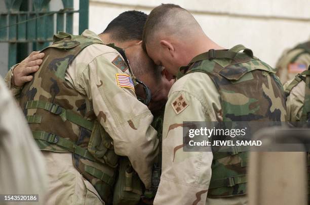 Soldiers from the 1st Battalioin, 22nd Infantry Regiment of the 4th Infantry Division, cries 02 February 2004 in Tikrit, during a memorial ceremony...