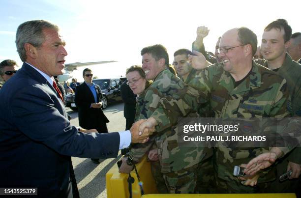 President George W. Bush greets US Air Force personnel before Air Force One departs Offuitt Air Force Base, in Omaha, Nebraska, 25 October 2004 after...