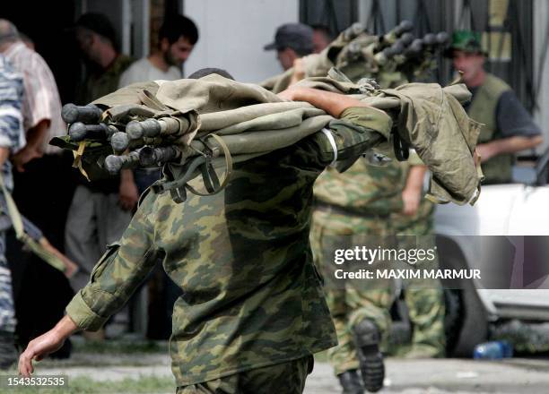 Russian soldiers carry stretchers during the rescue operation of Beslan's school, northern Ossetia, 03 September 2004. Dozens of corpses of dead...