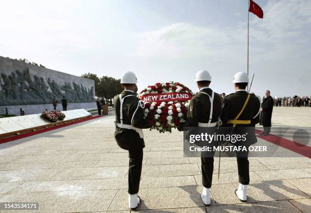 Turkish soldiers carry 25 April 2004 a wreath given by New Zealand toward the Canakkale Victory monument during the ceremony of the 89th anniversary...