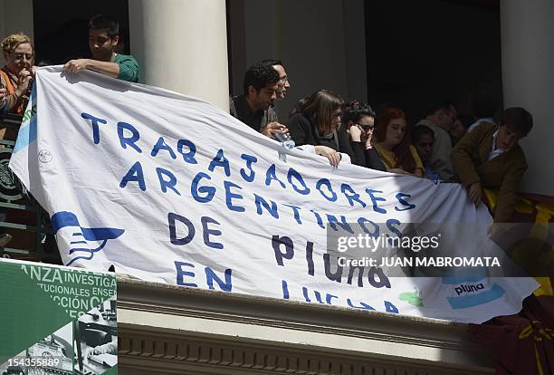Former workers of Pluna Uruguayan airlines hang a banner reading "Argentine workers of Pluna on fight" before Uruguayan President Jose Mujica...