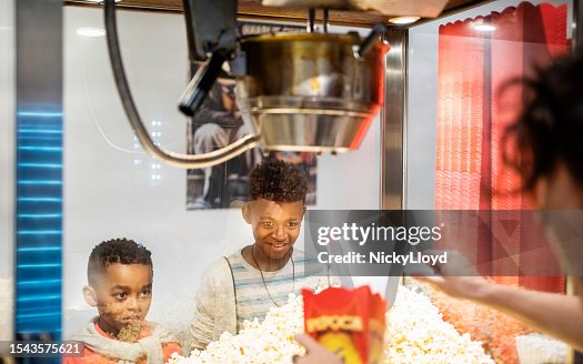 Two kids buying fresh popcorn in a movie theater Two kids buying fresh popcorn in a movie theater