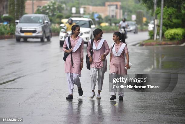 School Students during rain after schools reopen five days in the capital, on July 18, 2023 in New Delhi, India.