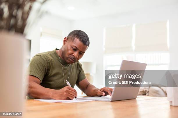 serious mature soldier continues education online - war veteran stock pictures, royalty-free photos & images