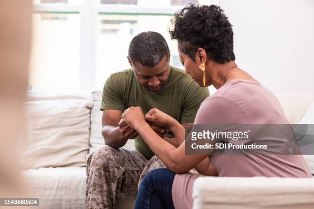 wife prays with soldier husband - couple praying stock pictures, royalty-free photos & images