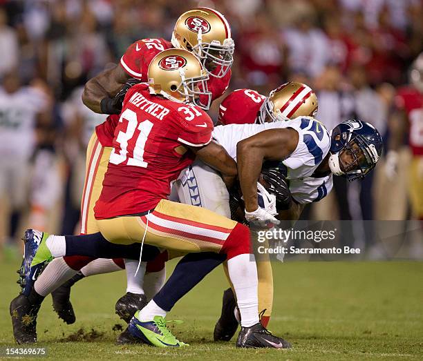 San Francisco 49ers strong safety Donte Whitner , inside linebacker Patrick Willis and defensive back Darcel McBath tackle Seattle Seahawks wide...