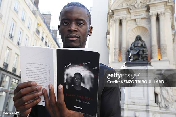 French Cameroonian-born student Jean Eyoum poses with his book on September 29, 2012 in Paris. Eyoum wrote "super cagnotte" a street-talk version of...