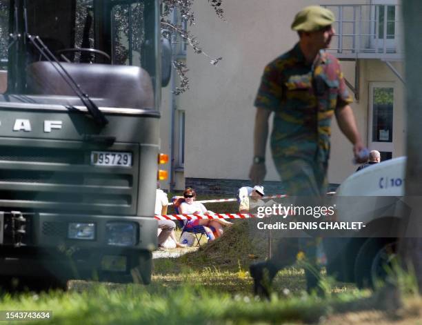 Substitute jury relax at the entrance of the Bastin Stockem area in the southeastern Belgian town of Arlon, 16 June 2004, where a sequestered jury is...