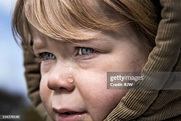 child with hood crying - tear face photos et images de collection