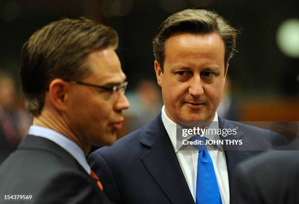 British Prime Minister David Cameron speaks with Finnish Prime Minister Jyrki Katainen at the start of the second day of an EU summit in Brussels on...