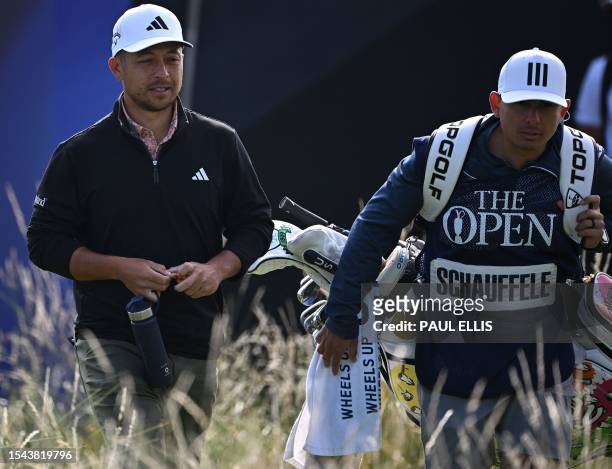 Golfer Xander Schauffele walks with his caddie away from the the 1st tee on day one of the 151st British Open Golf Championship at Royal Liverpool...