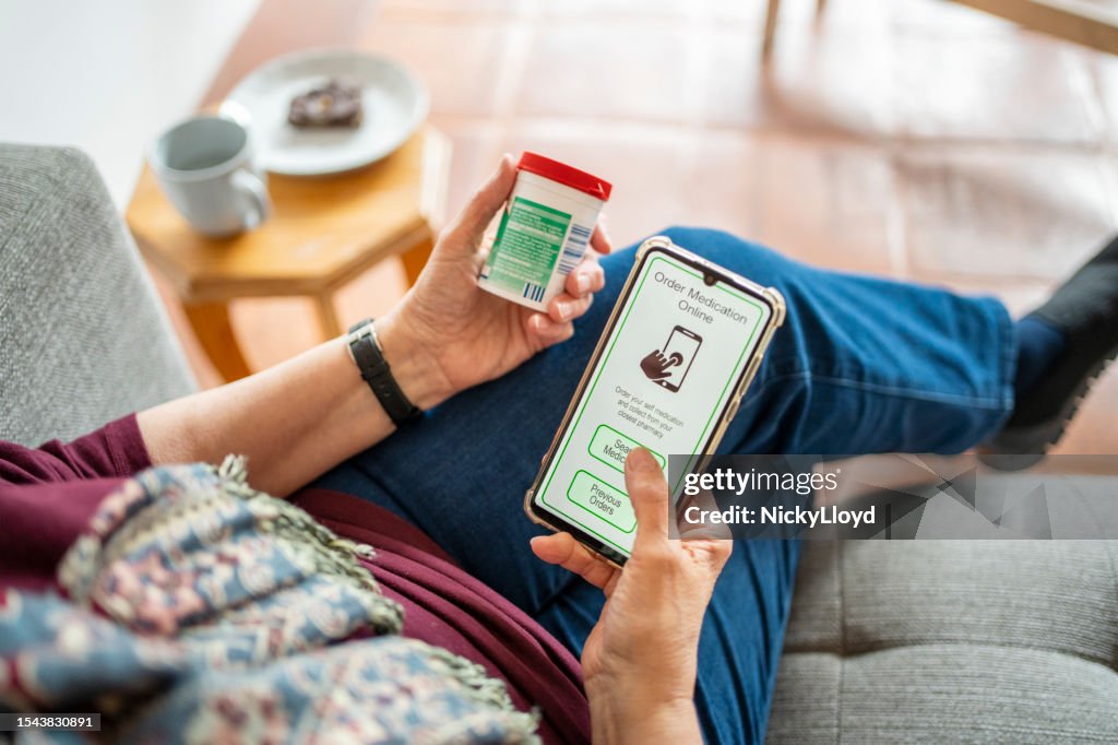Nahaufnahme einer älteren Frau, die mit einer mobilen App online Medikamente bestellt