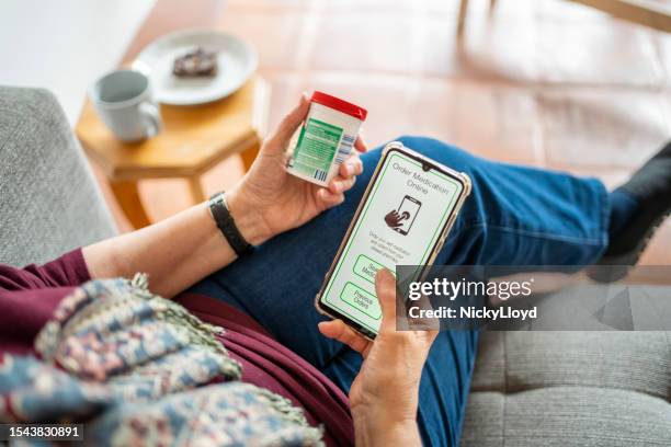 nahaufnahme einer älteren frau, die mit einer mobilen app online medikamente bestellt - verschreibungspflichtiges medikament stock-fotos und bilder