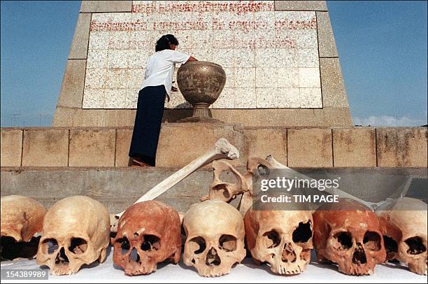 Woman places an offering into an urn behind a row of human skulls during " Day of Hate " ceremonies in this file photo dated 22 May 1992, marking the...