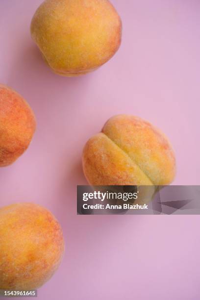 peach summer fruits over pink background from above - pfirsichkern stock-fotos und bilder