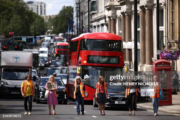 Traffic comes to a halt behind Just Stop Oil climate activists marching slowly in London on July 20, 2023. Human-made climate change is supercharging...