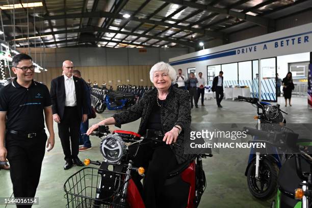Treasury Secretary Janet Yellen sits on an electric scooter as she visits the Selex Motors production plant in Hanoi on July 20, 2023.