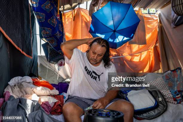 Homeless resident Michael Soes sits in his tent after missing the bus to a cooling center on July 14, 2023 in Phoenix, Arizona. Today marks the...