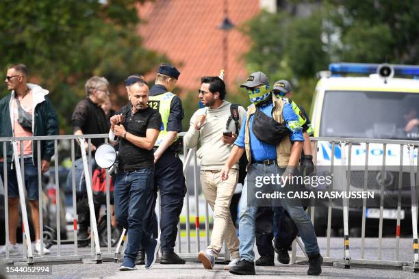 Protestor Salwan Momika is escorted by police to a location outside the Iraqi Embassy in Stockholm, Sweden, on July 20 where he allegedly plans to...