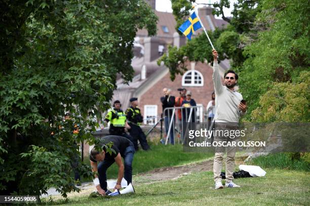 Protestor Salwan Momika holds up a Swedish flag during a protest outside the Iraqi Embassy in Stockholm, Sweden, on July 20, 2023. Iraq warned Sweden...