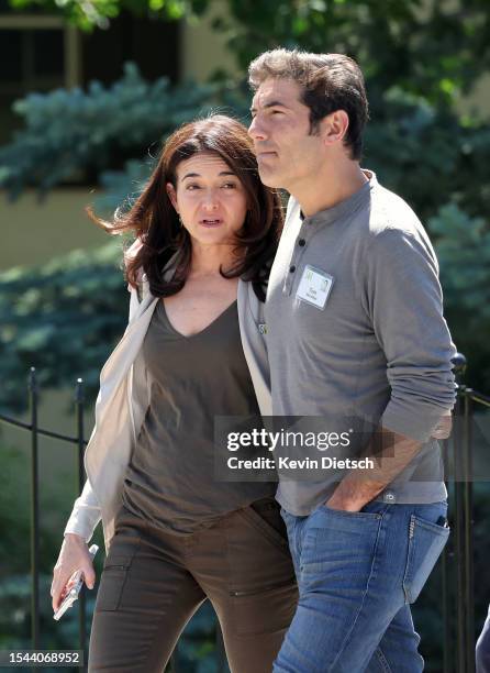 Sheryl Sandberg, former COO of Meta Platforms, and her husband Tom Bernthal walk to a morning session at the Allen & Company Sun Valley Conference on...