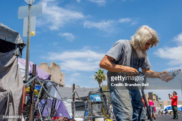 Homeless resident receives water from Wells Fargo Technology Services volunteers on July 14, 2023 in Phoenix, Arizona. Today marks the Phoenix area's...