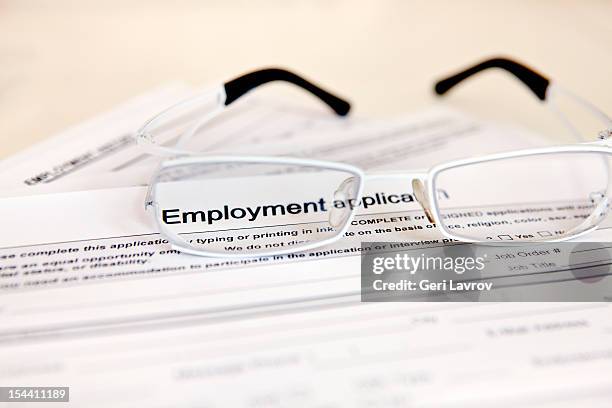 glasses and an employment application - aanvraagformulier stockfoto's en -beelden