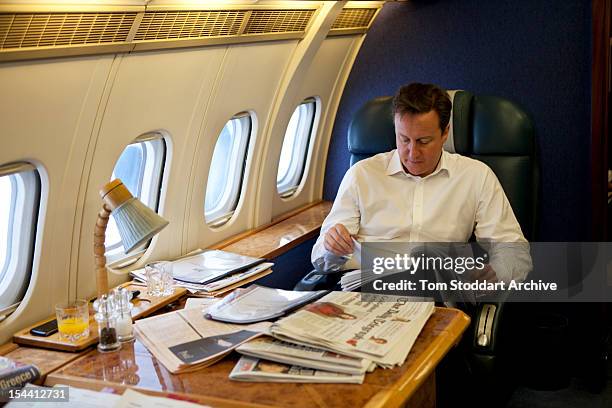 British Prime Minister David Cameron studies his notes during an RAF flight taking him and his team over Europe to attend the G20 Summit in Cannes,...