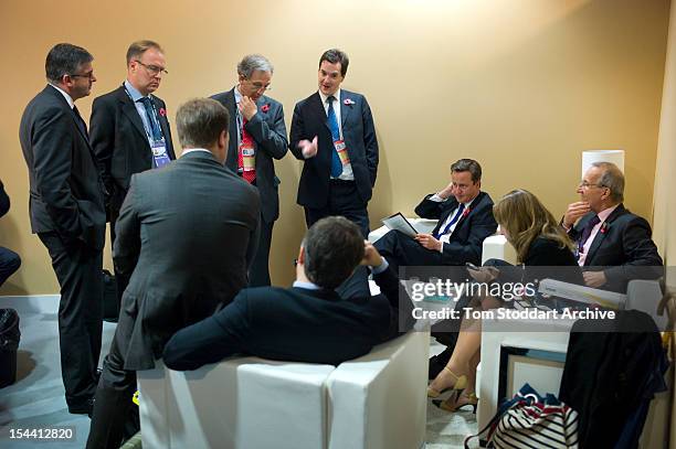 British Prime Minister David Cameron and Chancellor George Osborne in tense discussions with their senior advisors during the G20 Summit in Cannes,...