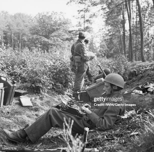 The British Airborne Division At Arnhem And Oosterbeek In Holland, War Correspondent Alan Wood is seen typing his despatch, cigarette in mouth while...