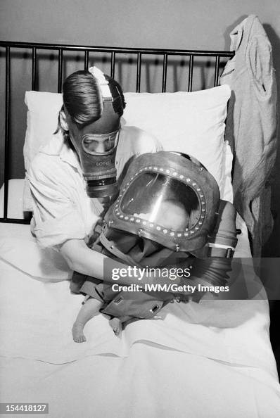 Air Raid Precautions On The British Home Front: Mother And Baby In Gas Masks, C 1941 Air Raid Precautions On The British Home Front: Mother And Baby In Gas Masks, C 1941