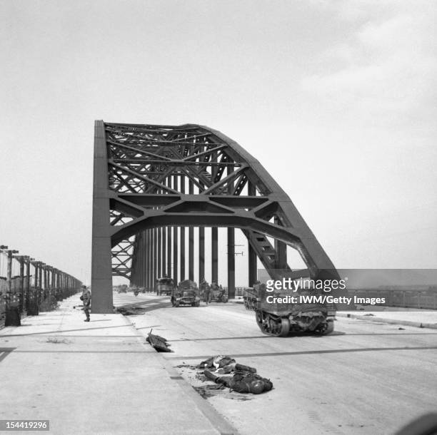 The British Army In North-West Europe 1944-45, Carriers and lorries crossing the bridge at Nijmegen, 21 September 1944. In the foreground is the body...