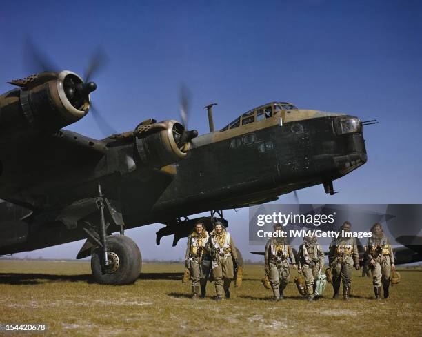 The Royal Air Force In Britain, Spring 1942, Aircrew in full flying kit walking beneath the nose of Short Stirling Mark I, N3676 'S', of 1651 Heavy...