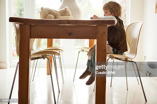 Boy at kitchen table with teddy and phone