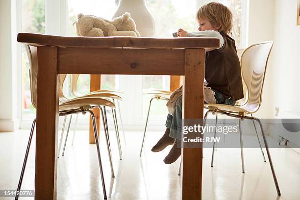 boy at kitchen table with teddy and phone - stuffed toy stock pictures, royalty-free photos & images