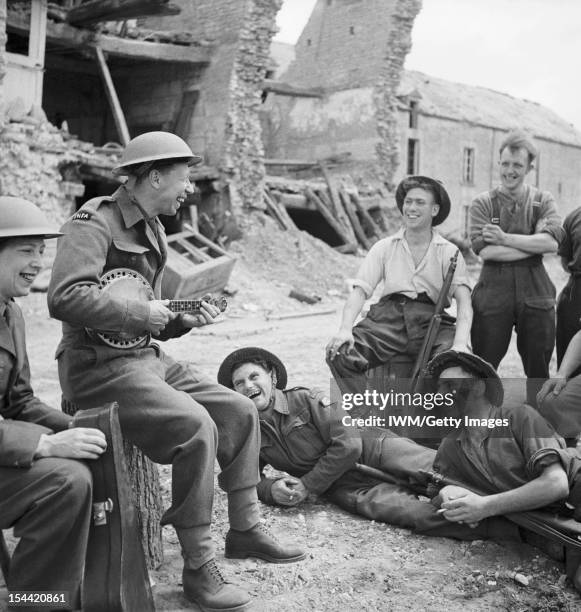 Leisure And Entertainment During The Second World War, George Formby entertains a group of soldiers in the ruins of a village in Normandy during the...