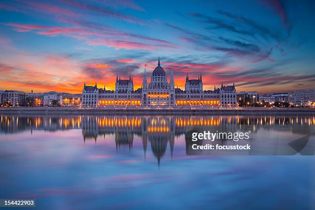 looking at hungarian parliament from across water at night - budapest stockfoto's en -beelden